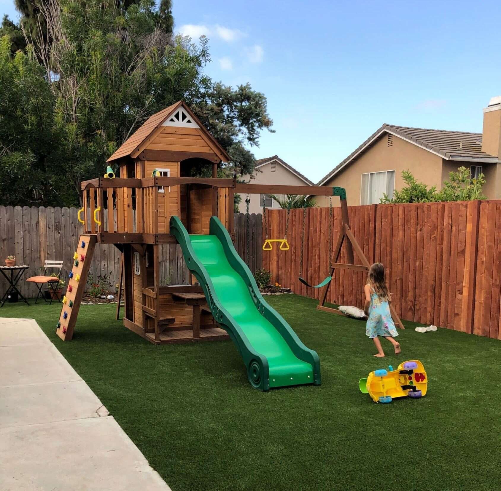 A child playing in the backyard on artificial grass