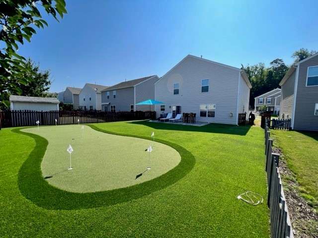 Artificial grass putting green in the backyard of a house