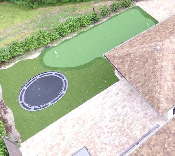 In ground trampoline and artificial turf yard