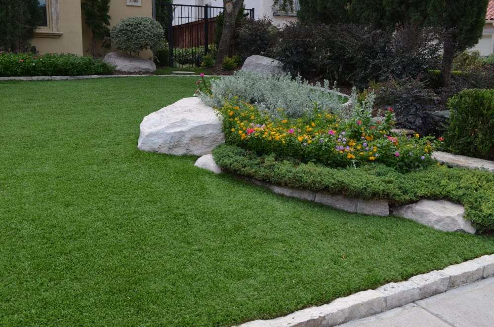 Garden and rocks surrounded by artificial grass