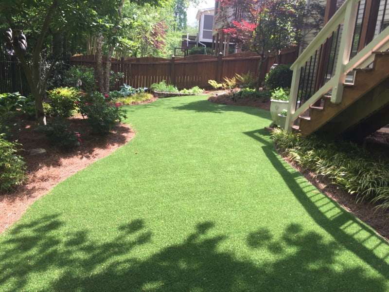 Stairs leading down to yard using artificial grass