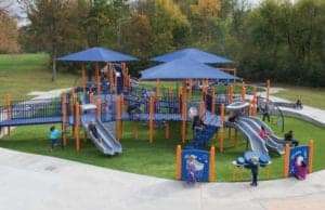 Northwoods park playground with kids playing on artificial turf