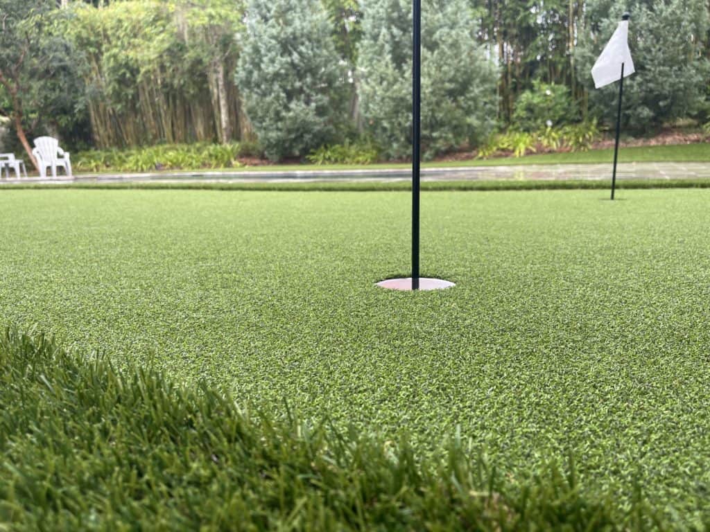 Artificial turf putting green with white flags