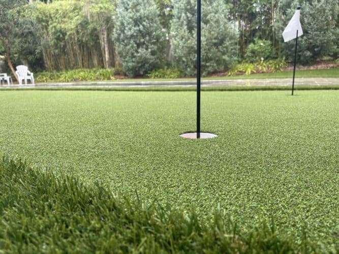 Artificial turf putting green with white flags