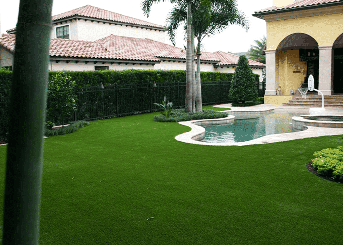 A pool in a backyard with artificial grass