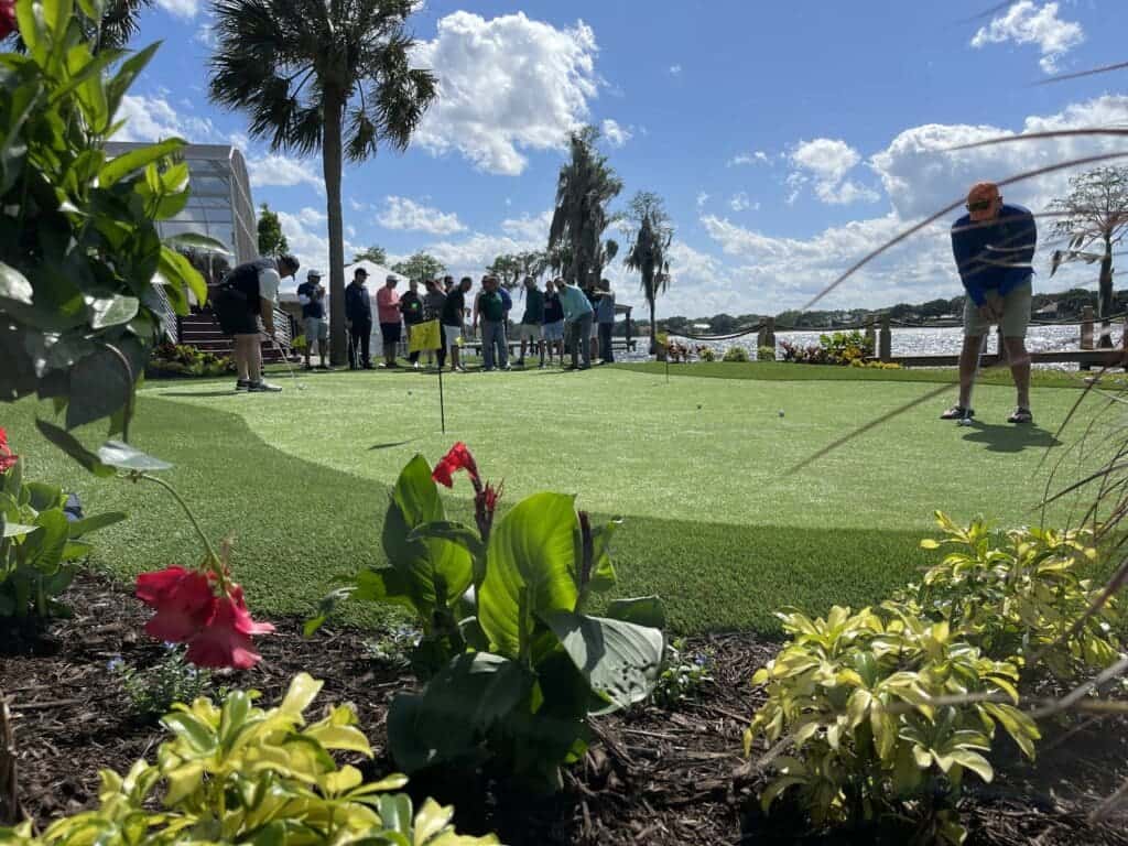 A group of people playing golf on artificial turf with a view of the ocean in orlando, fl