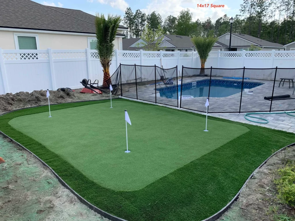 A pool with an artificial grass putting green golf course in the background
