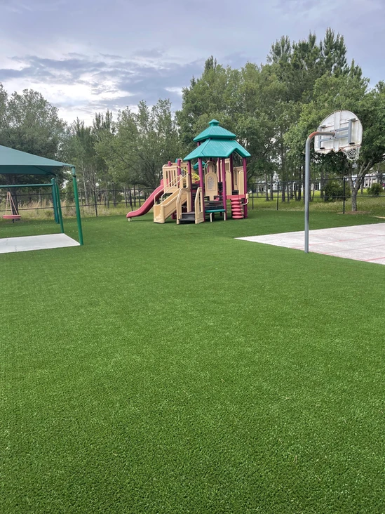 A playground in a park on artificial turf