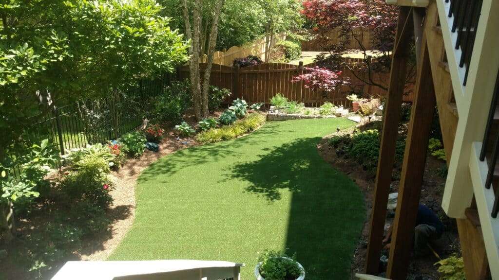Backyard artificial grass lawn with trees