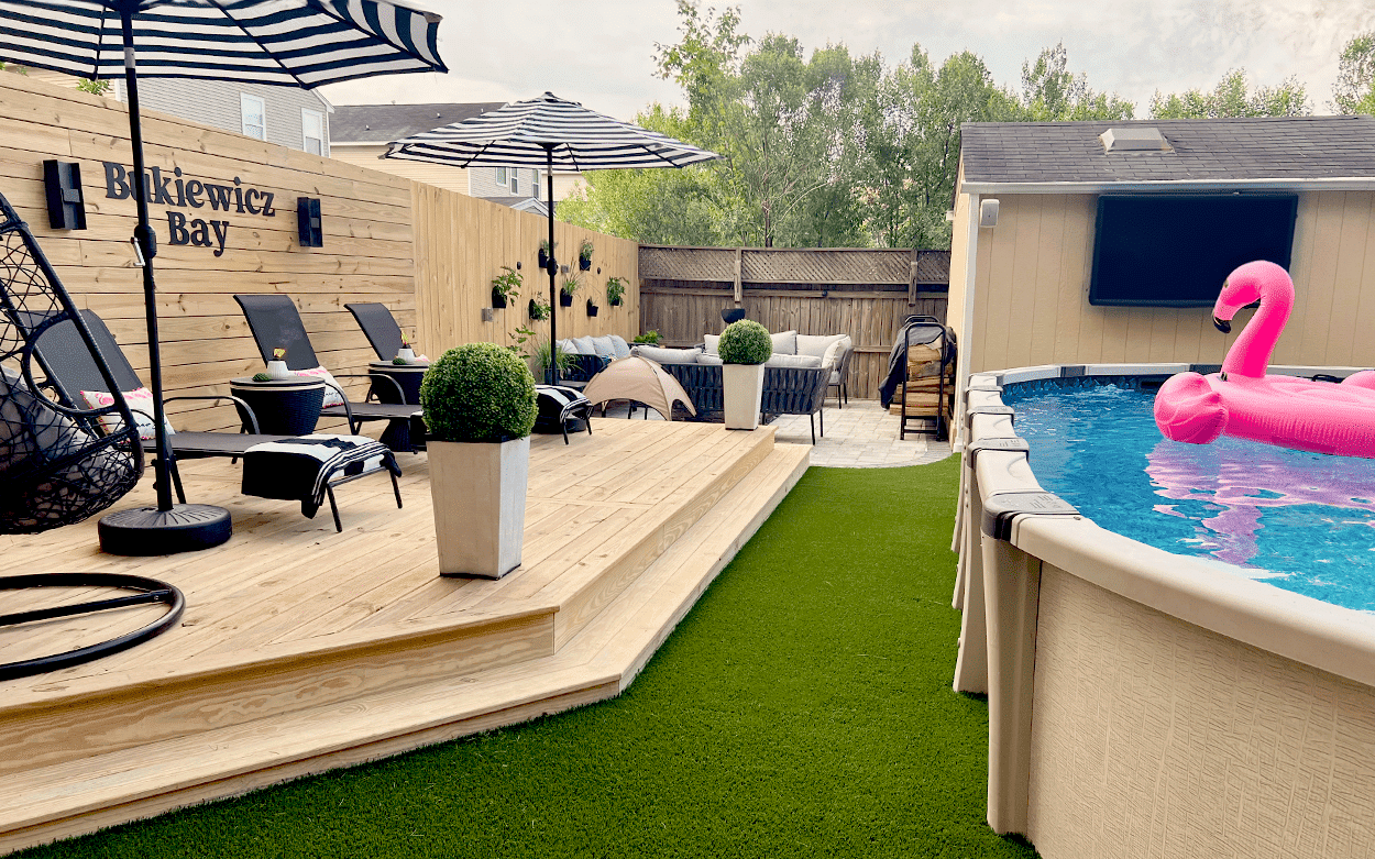 A pool with a pink flamingo in it surrounded by artificial turf