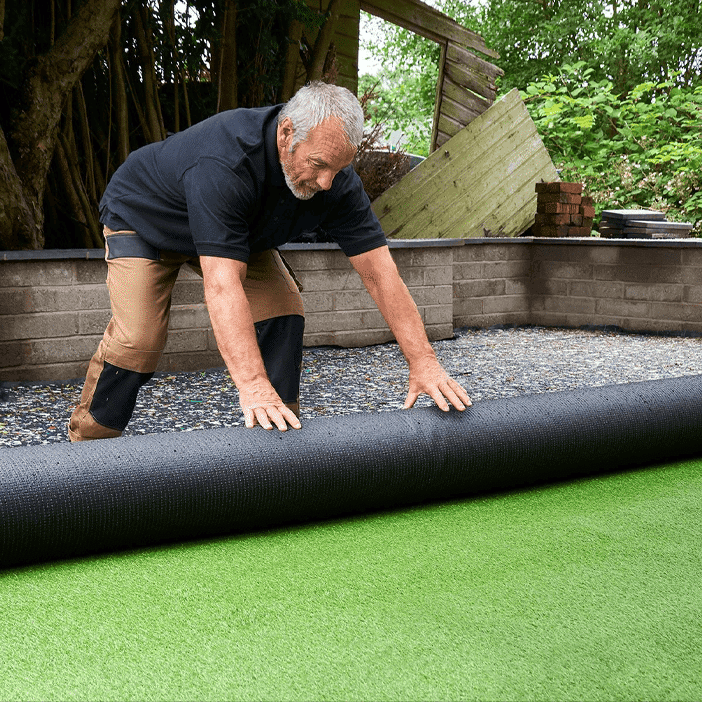 man rolling a turf roll out